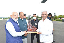 PM of India Narender Modi being presented with Baijnath temple replica by Guv Arlekar and CM Jai Ram Thakur  at Kangra airport on June 17